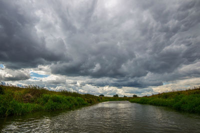 Scenic view of landscape against storm clouds