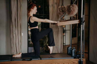 Side view of woman exercising at gym