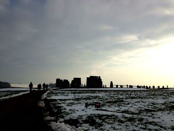 People on beach in city against sky