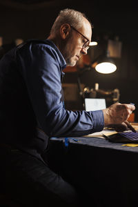 Side view of man working at table