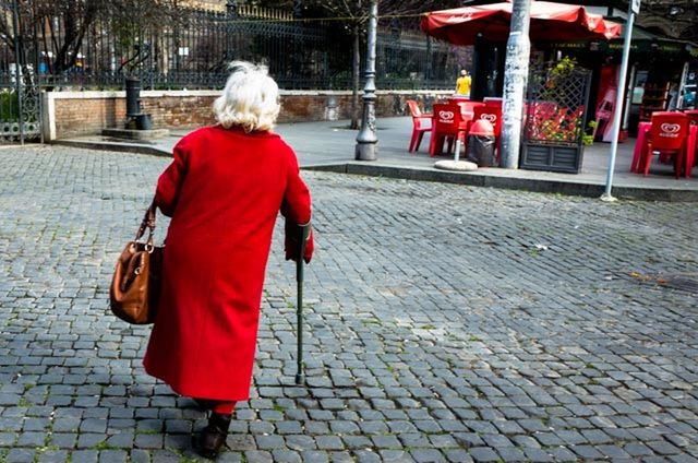 FULL LENGTH REAR VIEW OF WOMAN WALKING ON SIDEWALK