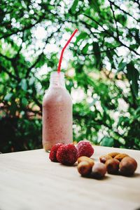 Strawberry smoothie with strawberries on table