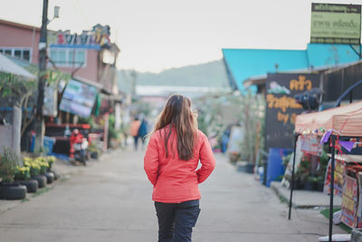 Rear view of woman walking on street in city