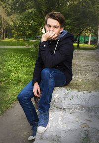 Portrait of young man sitting at park
