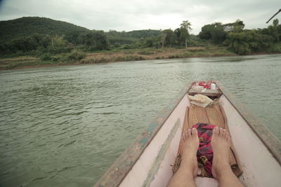 Low section of woman in lake against sky