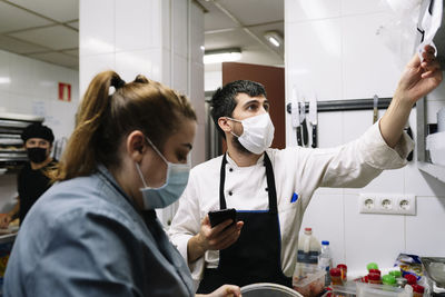 Male and female chef working in commercial kitchen during covid-19
