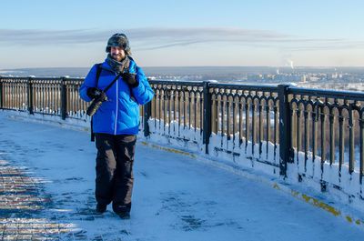 Portrait of man standing on snow covered footpath