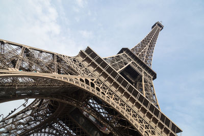 Low angle view of eiffel tower against cloudy sky