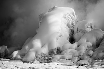 Snow covered rocks on field