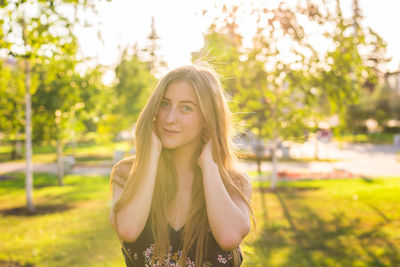 Portrait of smiling young woman standing against plants