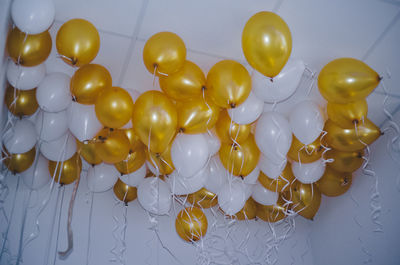 Close-up of multi colored balloons hanging against ceiling