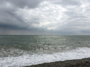 Scenic view of sea against storm clouds