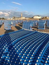 View of beach chair at beach against blue sky