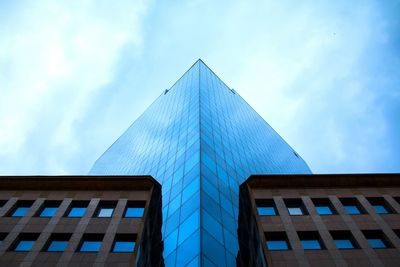 Low angle view of modern building against cloudy sky