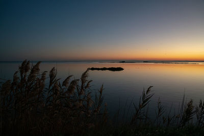 Scenic view of lake against sky during sunset