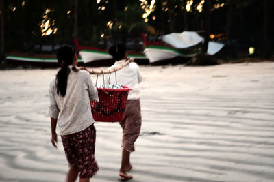 Rear view of people walking on street in city