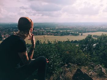 Woman looking at cityscape against sky