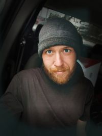 Portrait of man wearing knit hat sitting in car