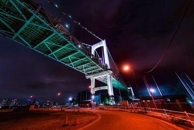 Illuminated bridge against sky at night