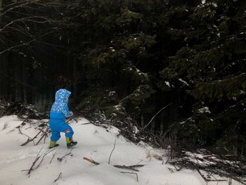 Rear view of child on snow covered land