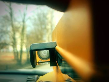 Close-up of person holding car windshield at sunset