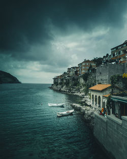 Scenic view of sea by buildings against sky