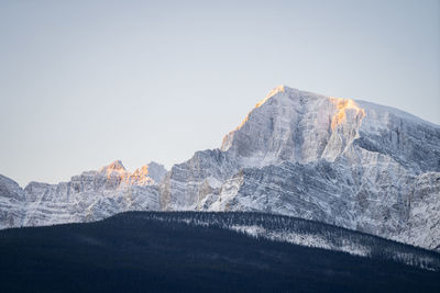Rocky peak catching the first light on a cold winter morning, narrow shot, banff n. park, canada