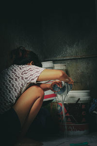 Midsection of woman sleeping on wall