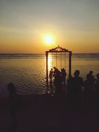 Silhouette of people at beach during sunset