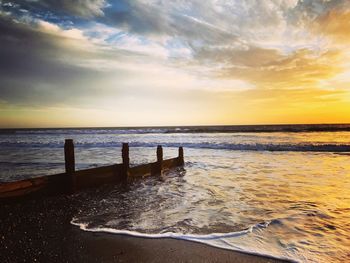 Scenic view of beach against sky during sunset