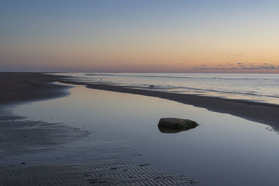 Scenic view of sea against clear sky at sunset