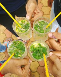 Low section of friends holding mojito glasses