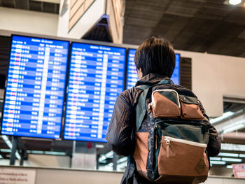 Rear view of man photographing at airport