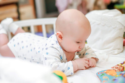 Portrait of cute baby boy sleeping on bed at home