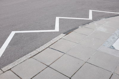 High angle view of road marking on city street by sidewalk