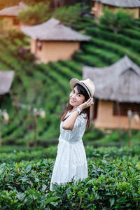 Woman wearing hat standing on field