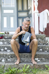 Mature man sewing shorts, oland, sweden