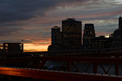 Low angle view of bridge and buildings against sky during sunset