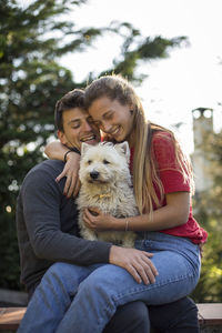 Portrait of woman with dog sitting outdoors