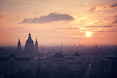 Church in city against sky during sunset