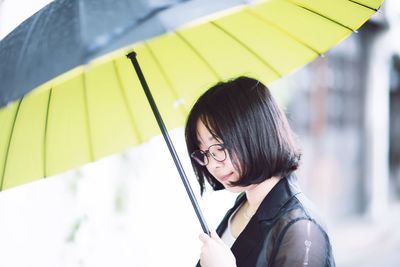 Woman holding umbrella during rainy season