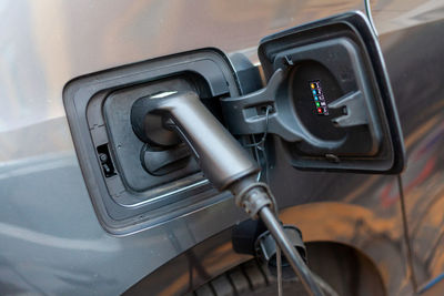 A cable is recharging an electric car at the charging station