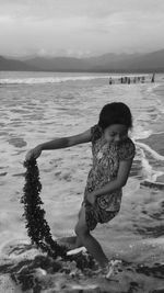 High angle view of girl standing on shore at beach