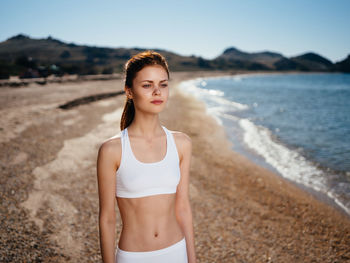 Portrait of young woman standing on beach