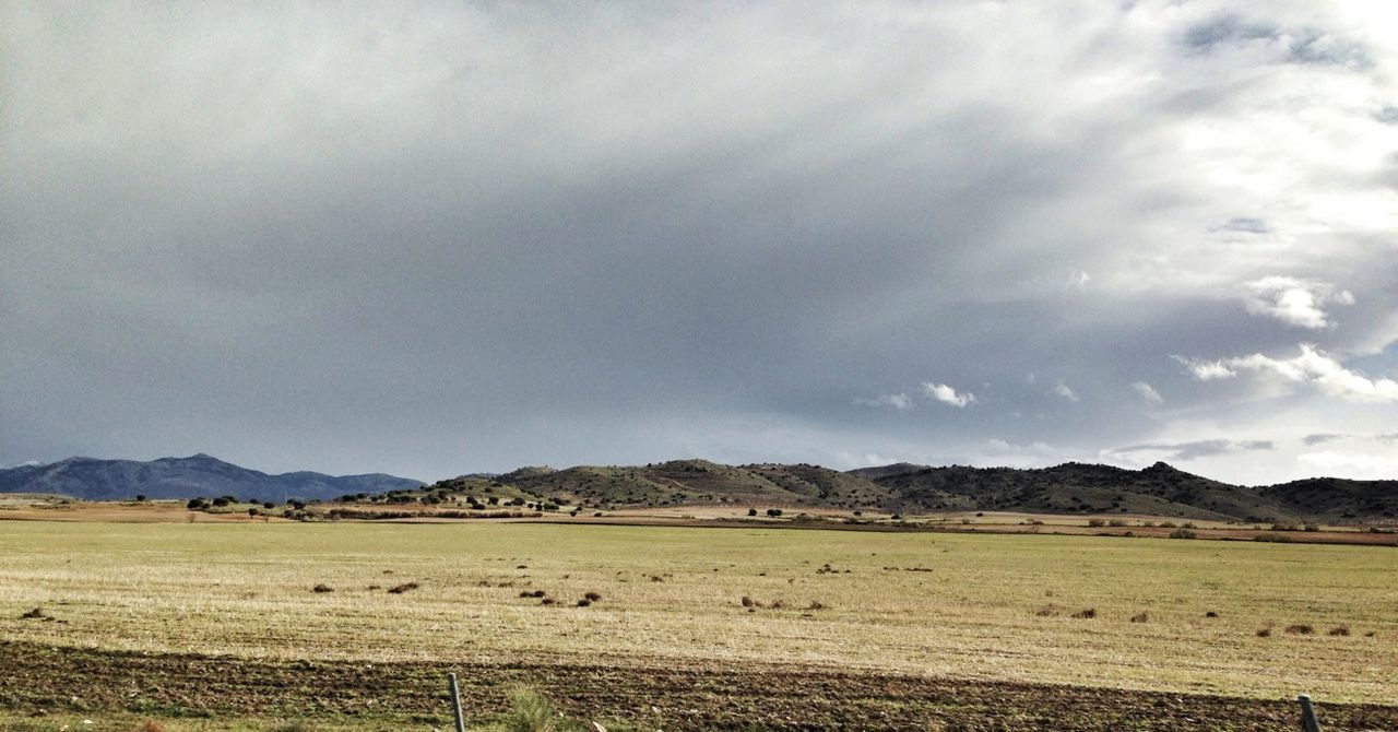 landscape, tranquil scene, sky, tranquility, scenics, mountain, cloud - sky, beauty in nature, mountain range, nature, cloudy, field, cloud, rural scene, non-urban scene, horizon over land, remote, idyllic, agriculture, day