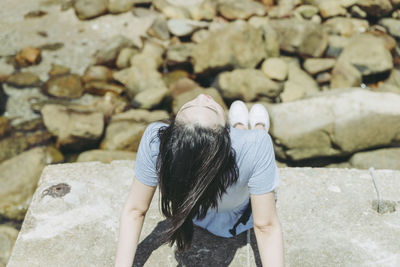 High angle view of woman sitting on rock