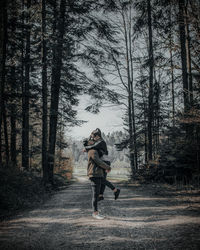 Full length of woman standing in forest