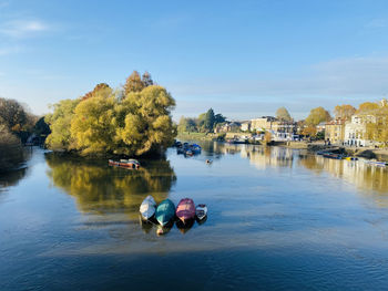 People on boat in lake against sky