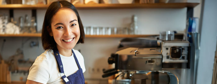 Portrait of young woman standing in cafe