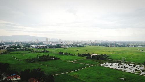High angle view of green landscape against sky